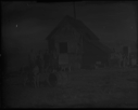 Image of Men and dogs by hunters' cabin
